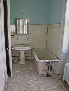 an old bathtub and sink in a run down bathroom