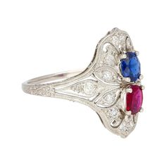 This is part of Chairish’s Fine Jewelry assortment.  This ring showcases a captivating interplay of color and light. A mesmerizing oval sapphire, boasting 0.48 carats, shimmers with a blue hue. Its brilliance is complemented by a fiery counterpart: an oval ruby radiating 0.33 carats of deep pink. 14 European-cut round diamonds, meticulously set, add a touch of elegance. Crafted from platinum, this ring offers both durability and sophisticated style.  All the gemstones are natural and the ring is Art Deco Oval Sapphire Ring With Accent Stones, Multicolor Oval Diamond Ring For Formal Occasions, Formal Multicolor Oval Diamond Ring, Multicolor Oval Heirloom Ring, Heirloom Style Multicolor Oval Rings, Heirloom Multicolor Oval Rings, Platinum Multi-stone Sapphire Ring, Multicolor Oval Sapphire Ring For Formal Occasions, Oval Multicolor Sapphire Ring For Formal Occasions