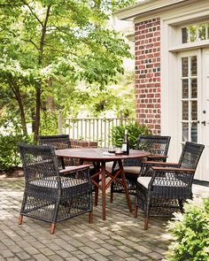 an outdoor dining table and chairs on a brick patio