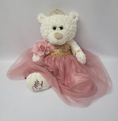 a white teddy bear wearing a pink dress