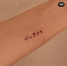 a woman's arm with the word happy written in small black ink on it