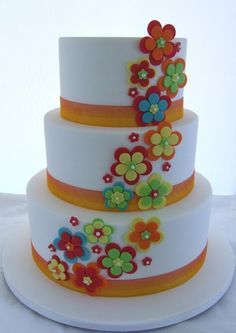 a three tiered cake with flowers painted on it