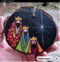 a hand painted wooden ornament depicting three wise men