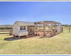 a barn with a shed attached to it in the middle of a field