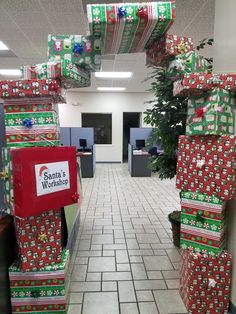 an office cubicle decorated for christmas with presents on the desks and wrapped in wrapping