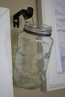 a mason jar hanging on the wall next to a window sill with an outlet