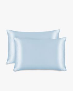 two light blue pillows sitting next to each other