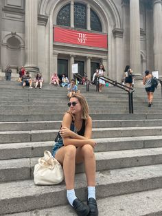 a woman sitting on steps in front of a building