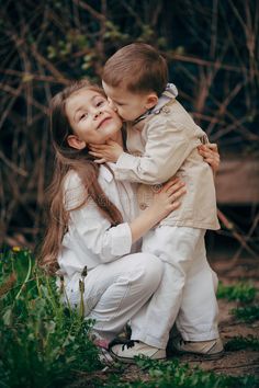 two children are hugging each other in the grass