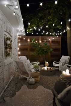 an outdoor patio with white chairs and string lights