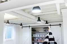 an open storage area in a white room with black and white accessories hanging from the ceiling