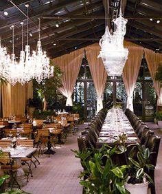 an indoor dining area with chandeliers and tables