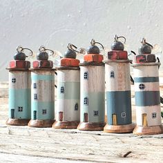 seven small lighthouses are lined up on a wooden table