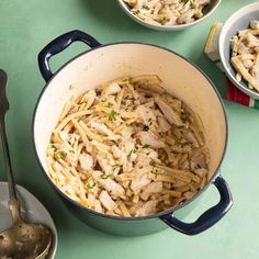 pasta with chicken and parmesan cheese in a blue pot on a green table