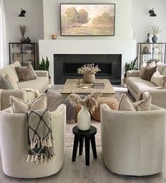 a living room with couches, chairs and a fire place in the middle of it