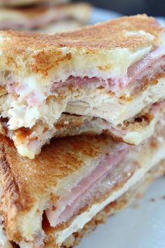 two halves of a ham and cheese panini stacked on top of each other,