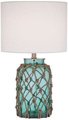 a blue glass table lamp with a white shade on the top and bottom part of it