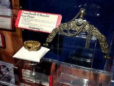 a display case with an ornate crown and other items on the shelf in front of it