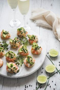 small appetizers are arranged on a plate with limes and garnishes