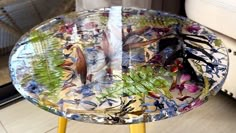 a glass table with flowers and plants on it