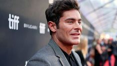 a close up of a person wearing a suit and tie on the red carpet at an event