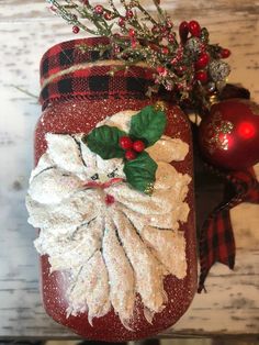 a red jar decorated with holly and white flowers