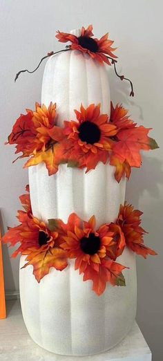 a three tiered white pumpkin decorated with sunflowers