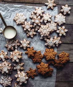 some cookies are sitting on a piece of paper next to a cup of milk and spoon