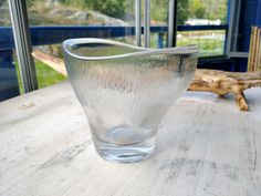 a glass vase sitting on top of a wooden table