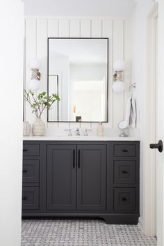 a white and black bathroom with two sinks