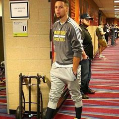 a man standing next to a luggage cart in a hallway