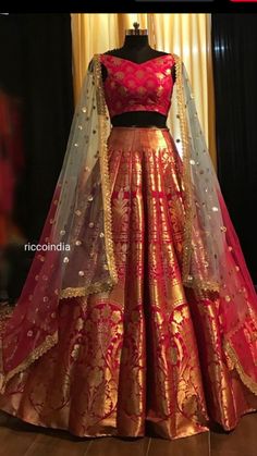 a red and gold lehenga is displayed on a mannequin