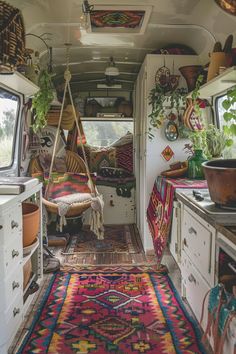 the interior of an rv with colorful rugs and potted plants hanging from the ceiling