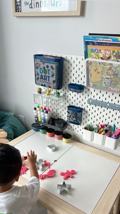 a little boy that is sitting at a table with some crafting supplies on it