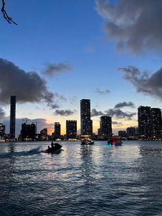 boats are in the water near tall buildings