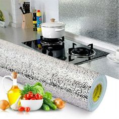 a roll of paper sitting on top of a counter next to vegetables and other items