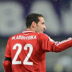 a soccer player giving the thumbs up to his team mate on the field in the rain