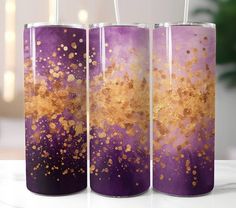 three purple and gold vases sitting on top of a table