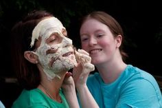 two girls are smiling and having their faces covered in white frosting while one girl holds up her face to the camera