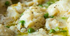 a close up of food in a bowl with peas and cheese on top, as well as broccoli