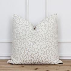 a white pillow sitting on top of a wooden floor