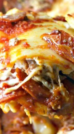 a close up of a slice of lasagna with meat and cheese on it