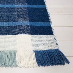 a blue and white blanket laying on top of a wooden floor