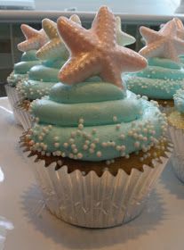 three cupcakes with blue frosting and starfish decorations