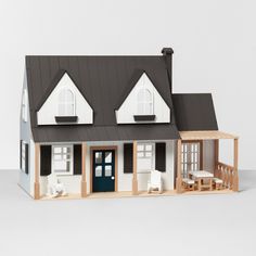 a model house is shown in front of a white background with black roof and windows