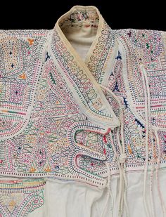 an embroidered white jacket with colorful designs on it