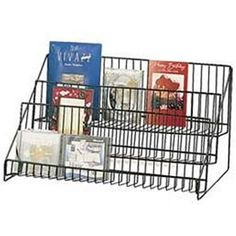 a wire basket with books and greeting cards in the bottom section, on a white background