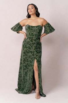 a woman wearing a green dress with an off the shoulder top and high slit skirt