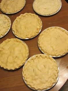 six pies sitting on top of a wooden table