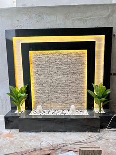 a fire place with some plants and rocks in front of it on top of the floor